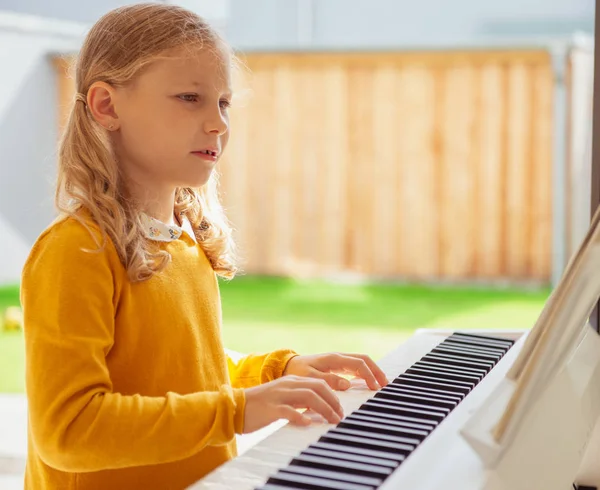 Retrato de menina bonita ter aula de piano no whi moderno — Fotografia de Stock