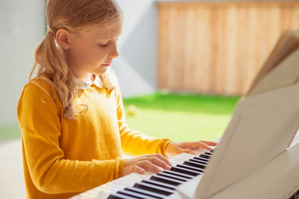 Porträtt av vacker liten flicka med pianolektion på modern WHI — Stockfoto