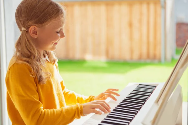 漂亮的小女孩在现代whi有钢琴课的肖像 — 图库照片