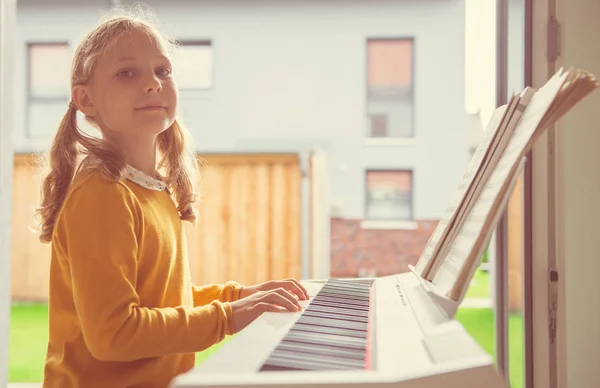 Retrato de menina bonita ter aula de piano no whi moderno — Fotografia de Stock