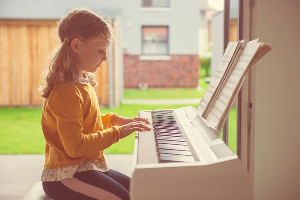 Portret całkiem małej dziewczynki o lekcji fortepianu w nowoczesnym WHI — Zdjęcie stockowe