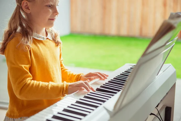 Portrait of pretty little girl having piano lesson at modern whi — Stock Photo, Image