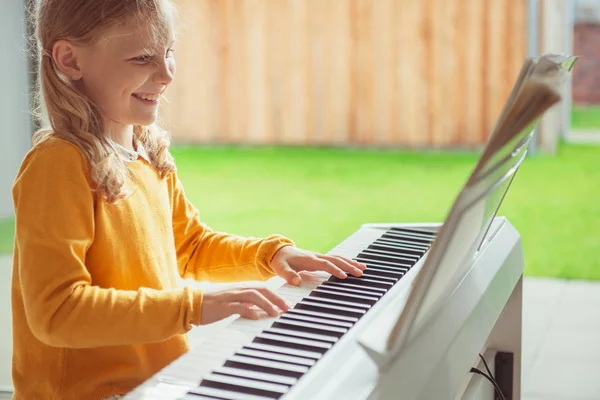 Портрет красивой маленькой девочки с уроком фортепиано в современном whi — стоковое фото