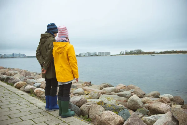 年轻的兄弟姐妹们穿着高矮的橡胶在波罗的海沿岸散步 — 图库照片