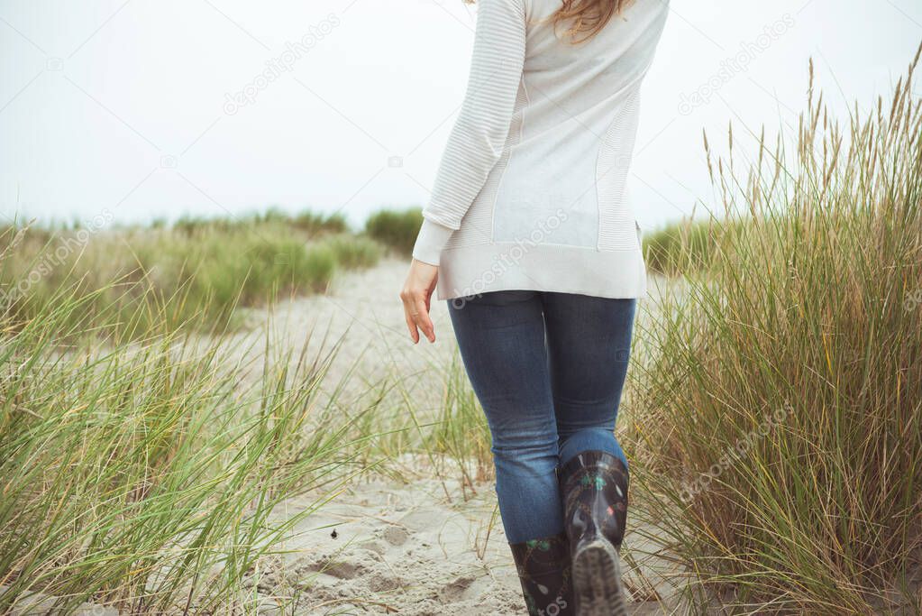 Attractive woman walking in sand dunes at Baltic sea costline in