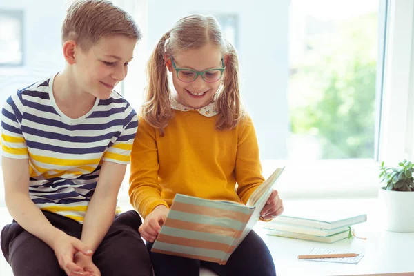 Két Boldog Tinédzser Gyerek Asztalon Olvas Egy Vicces Könyvet Ünnepnapokon — Stock Fotó