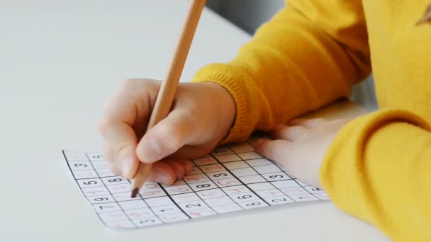 身近な子どもたちの手で 趣味として鉛筆でパズルを解く映像 — ストック動画