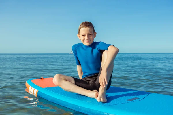幸せなティーン子供男の子楽しんでいると作る上のボード上の水でバルト海 — ストック写真