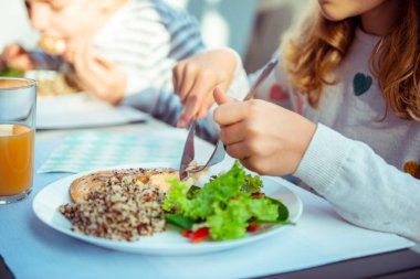 Terasta taze salata, kinoa ve balıkla sağlıklı yemek yiyen kız çocuklarının fotoğraflarını çek.