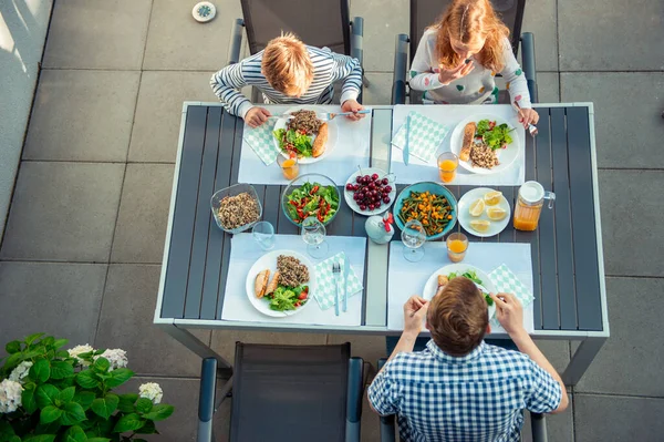 テラスで一緒に健康的なディナーを食べる幸せな家族の上からの写真の景色 — ストック写真