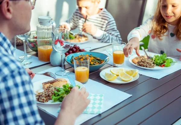 幸せな家族は家でテラスで一緒に健康的なディナーを食べる — ストック写真