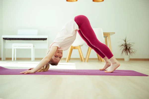 Evde Yoga Yaparken Eğlenen Mutlu Bir Kız Çocuğu — Stok fotoğraf