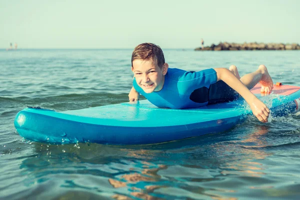 幸せなティーン子供男の子楽しんでいると作る上のボード上の水でバルト海 — ストック写真