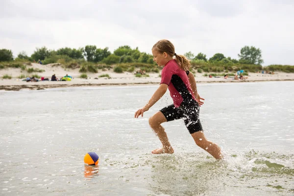 在波罗的海玩球和跑步 快乐而又漂亮的年轻姑娘 穿着氯丁橡胶泳衣 — 图库照片
