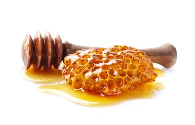 Beyaz arka planda kaşığı olan bal peteği