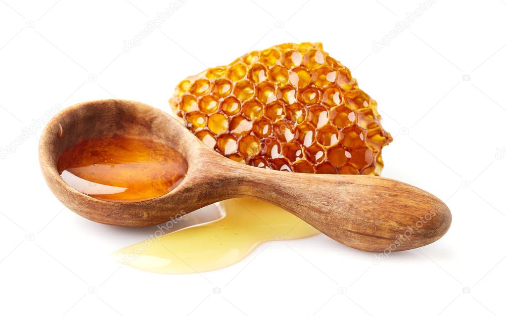 Honey in wooden spoon with honeycomb
