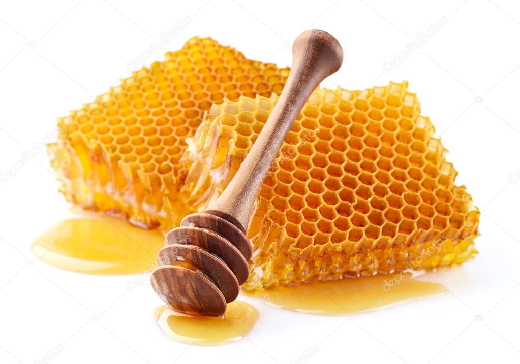 Honeycomb with wooden spoon in closeup