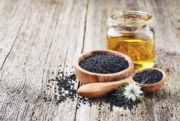 Black cumin oil with seeds and flower nigella sativa — Stock Photo, Image