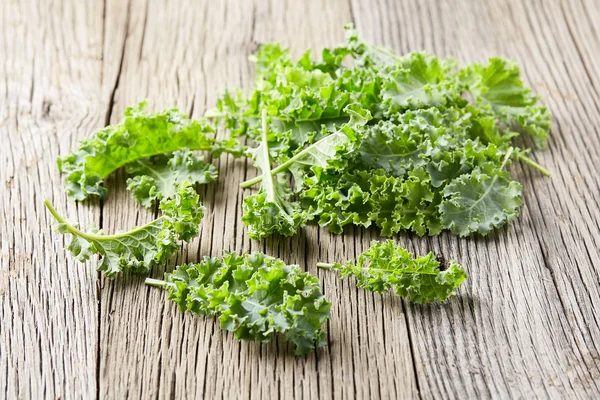 Kale bladeren op houten ondergrond — Stockfoto