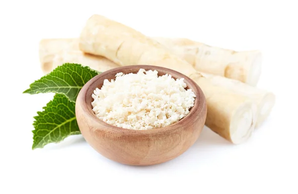 Horseradish root and grated horseradish in wooden plate on white — Stock Photo, Image