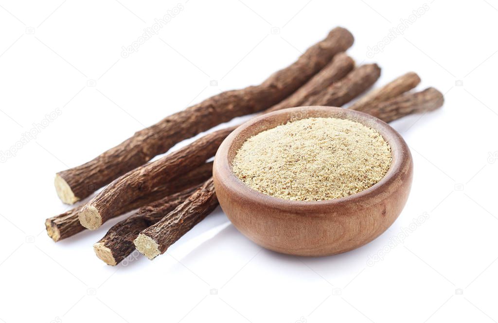 Licorice powder with dry roots on white background