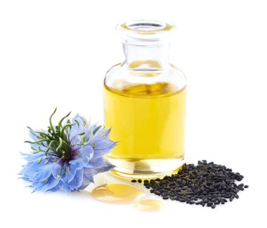 Beyaz arka planda tohumları olan siyah kimyon yağı.