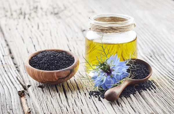 Schwarzkümmelöl Mit Blütennigella Sativa Auf Holzbrett — Stockfoto