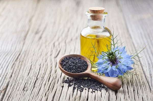 Olio Cumino Nero Con Fiore Nigella Sativa Fondo Legno — Foto Stock