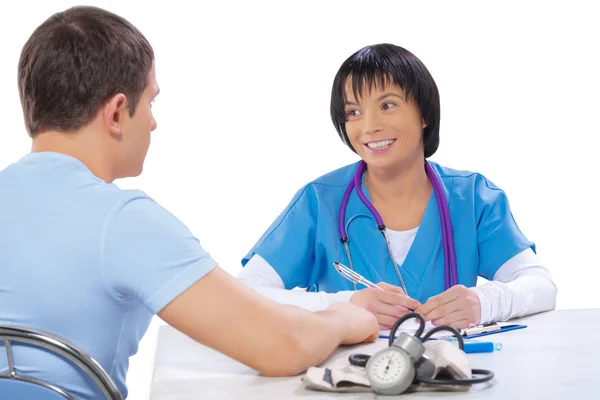 Kobieta lekarz i pacjent w tabeli na białym tle — Zdjęcie stockowe