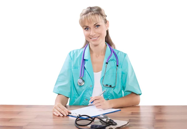 Schöne lächelnde Ärztin am Tisch mit Blick auf Kamera-Isol — Stockfoto