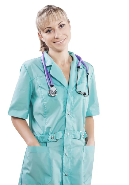 A smiling beautiful blonde female doctor with hands in pockets l — Stock Photo, Image