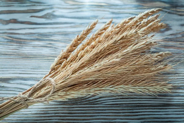Bunch of wheat ears on vintage wooden board — Stock Photo, Image