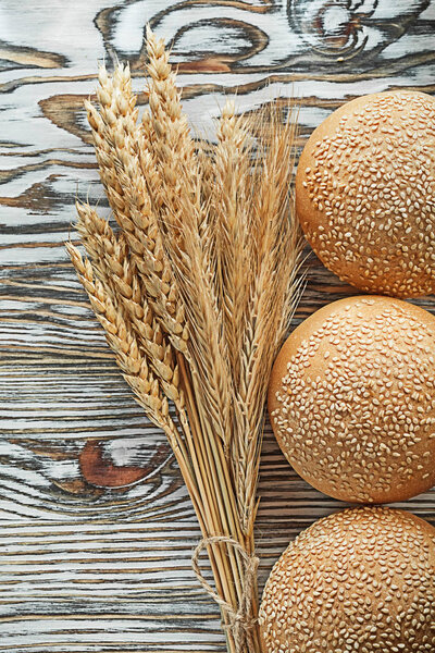 Crusty bread bunch of rye ears on vintage wooden surface