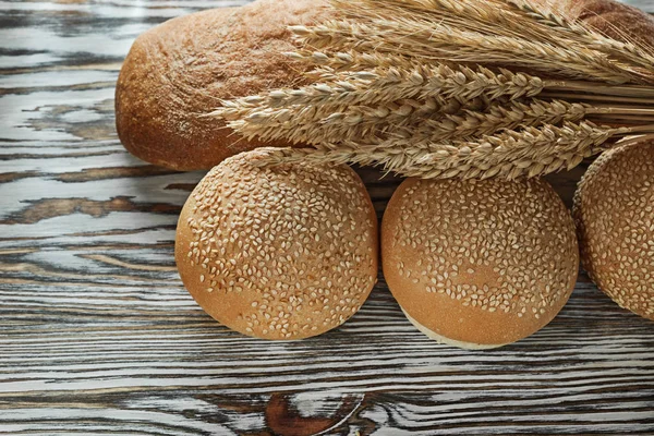 新鲜面包长面包小麦耳朵在木表面 — 图库照片
