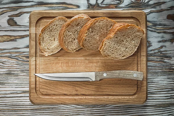 Schneidebrettmesser geschnittenes Brot auf Holzoberfläche — Stockfoto