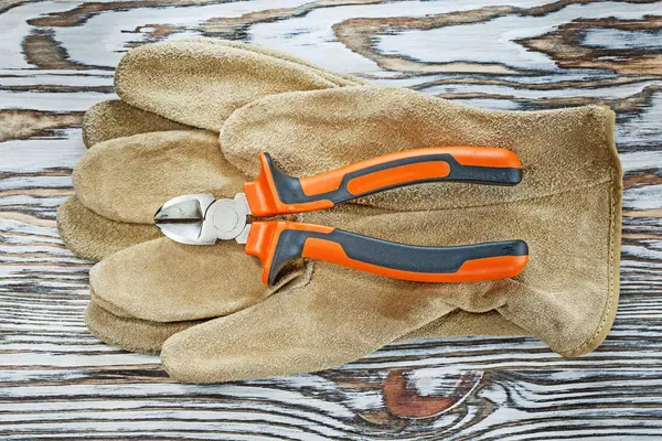 Gants de protection en cuir pinces sur planche en bois — Photo