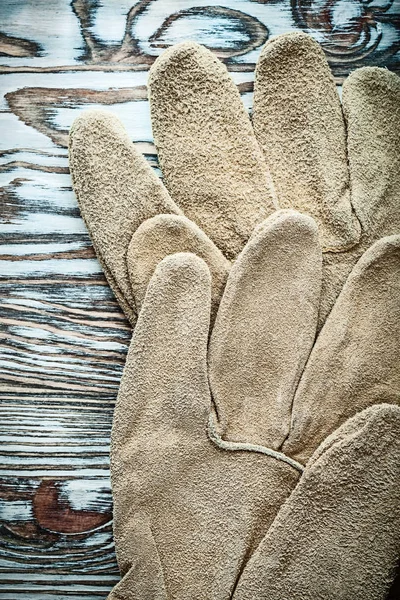 Paire de gants de protection en cuir sur planche en bois — Photo