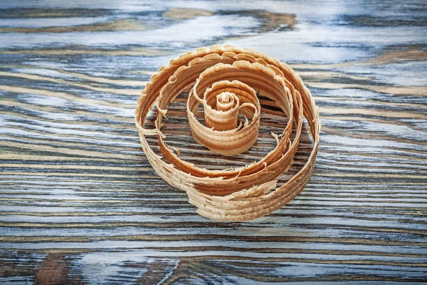 Curled planning chips on wooden board — Stock Photo, Image