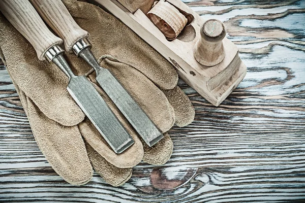 Guantes de seguridad cepilladora cinceles planos sobre tabla de madera — Foto de Stock