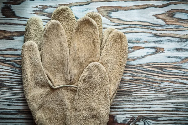 Pair of protective gloves on wooden board