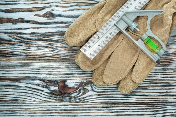 Emanet eldiven inşaat seviyesi kare cetvel üzerinde ahşap tahta