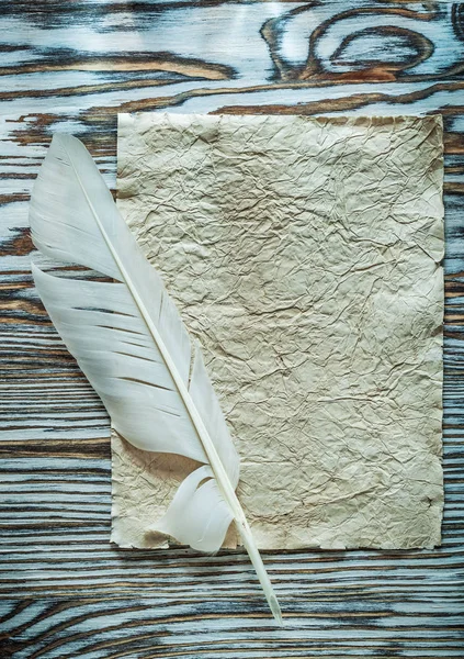 Folha vintage de pluma de papel na placa de madeira — Fotografia de Stock