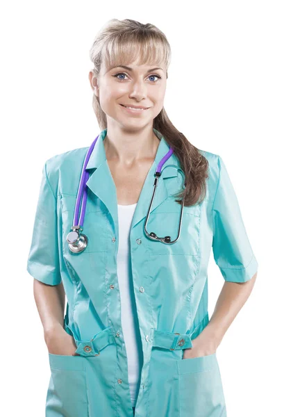 Doctora con brazos cruzados sosteniendo las manos en bolsillos mirando — Foto de Stock