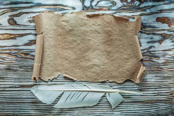 Pluma de pergamino de papel vintage en tablero de madera — Foto de Stock