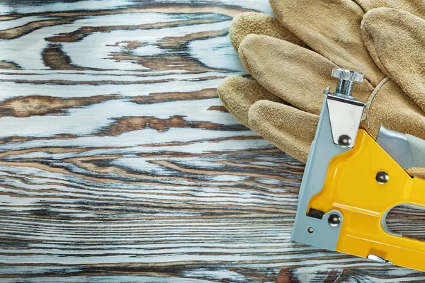 Kožené ochranné rukavice stavební sešívačka na dřevěné desce — Stock fotografie