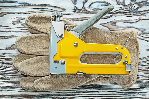 Sarung tangan keselamatan kulit stapler konstruksi di papan kayu — Stok Foto
