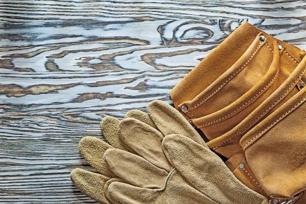 Kožené ochranné rukavice nástroj pás na dřevěné desce — Stock fotografie