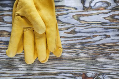 Ahşap tahta üzerinde sarı deri koruyucu eldivenler
