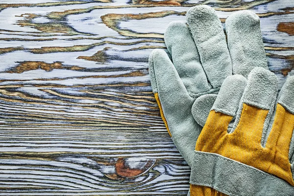 Gele beschermende handschoenen op houten bord — Stockfoto