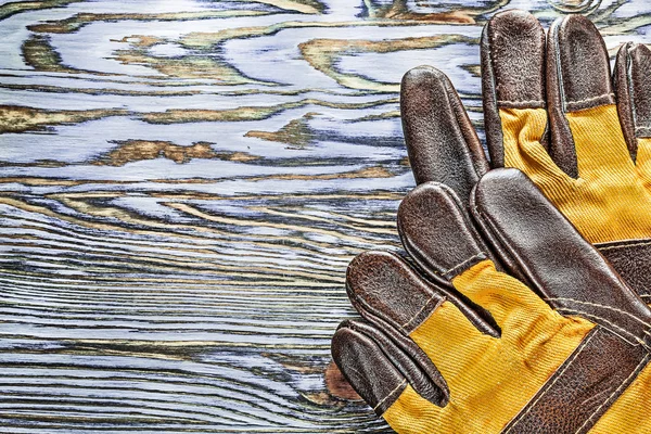 Pair of working gloves on wooden board